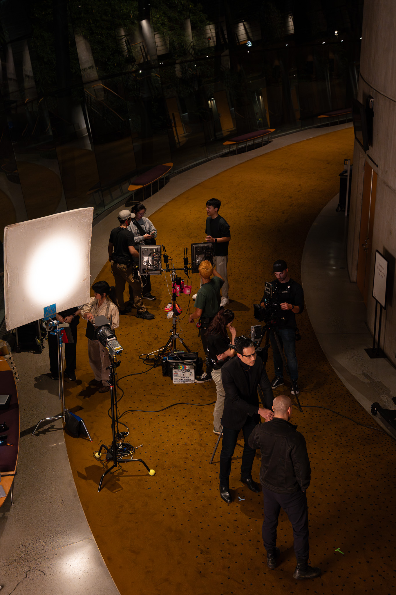 Overhead view of the film crew setting up a shot with lights, monitors and a clapperboard